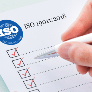 Mano escribiendo hoja sobre la ISO-19011-2018